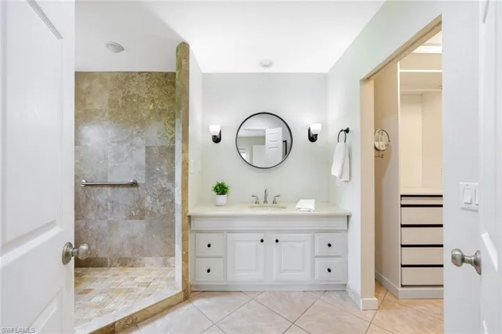 Walk in shower with custom closets in closet.