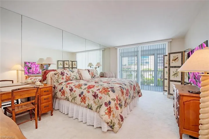 Wall-to-wall carpeting and full-length mirrored wall panels enhance the room's dimensions