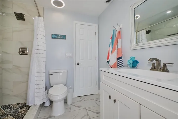 Bathroom featuring vanity, toilet, and walk in shower