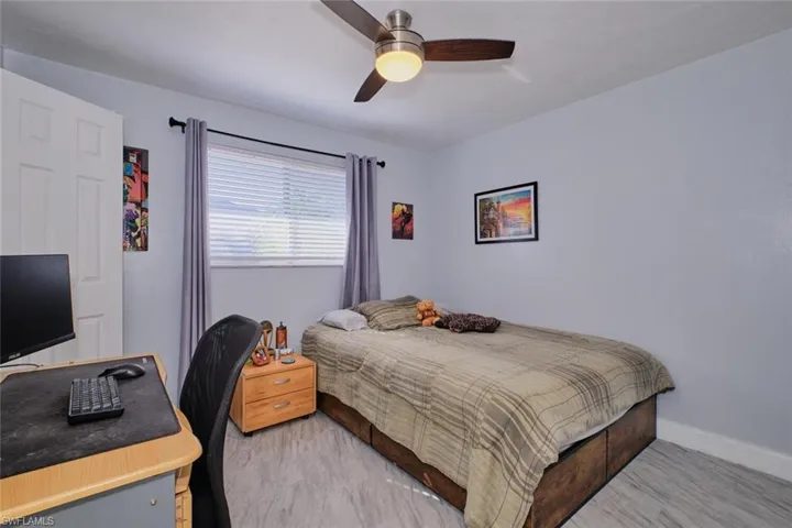 Bedroom with ceiling fan and light carpet