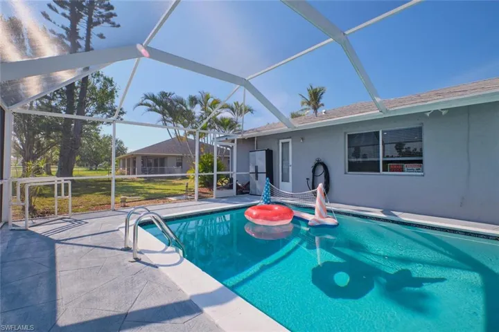 View of pool with a yard, a patio, and a lanai