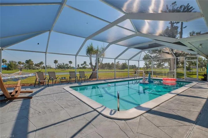 View of swimming pool with a patio, a jacuzzi, a lanai, and a lawn