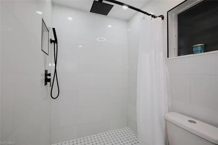 Bathroom with toilet and a shower with curtain