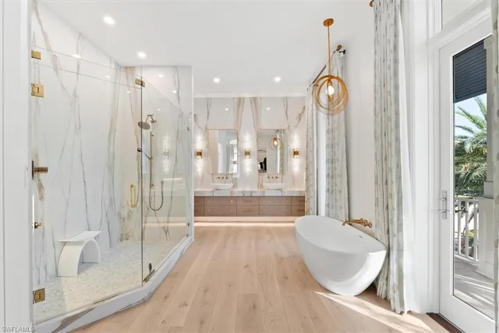 Bathroom with vanity, wood-type flooring, and plus walk in shower