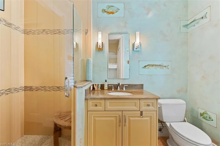 Bathroom with vanity, toilet, and a shower with shower door