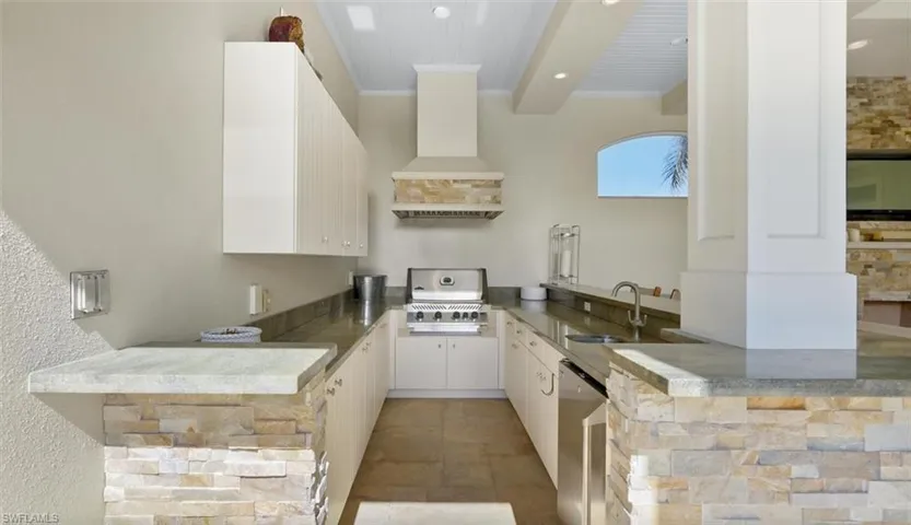 Kitchen featuring kitchen peninsula, sink, dishwasher, and white cabinets