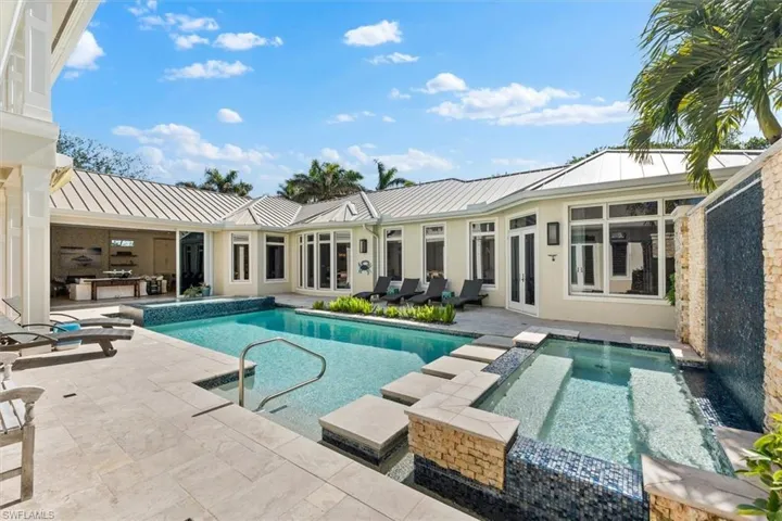 View of pool with a patio area and an in ground hot tub