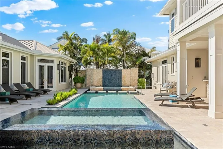 View of swimming pool with french doors, an in ground hot tub, and a patio area