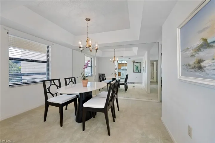 Dining room with a tray ceiling and  chandelier