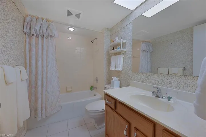 Full Bathroom with light tile flooring, shower / bath combo and vanity