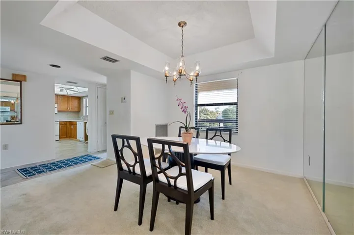 Dining room with a tray ceiling and  chandelier