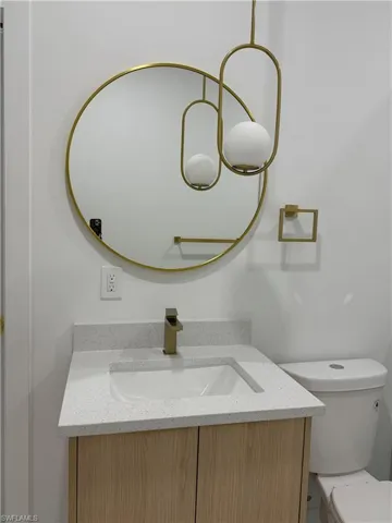 Half bathroom featuring vanity and toilet