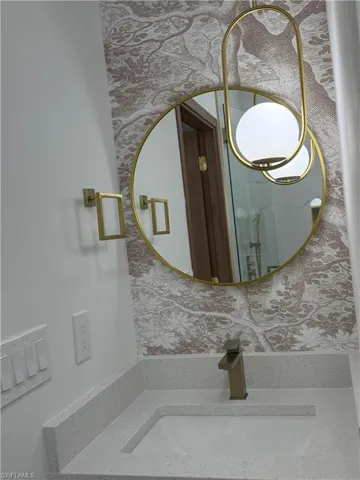 Bathroom view of vanity and wallpapered walls