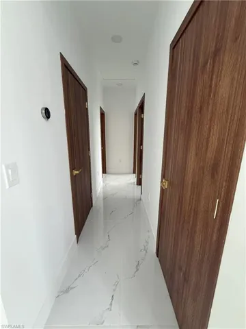 Hall featuring marble finish floors and baseboards