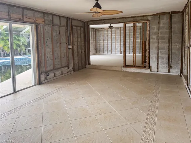 Empty room featuring light tile patterned flooring and a ceiling fan