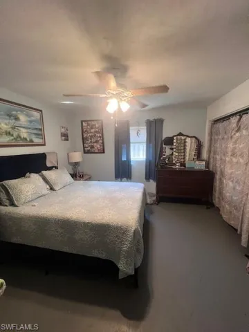 Carpeted bedroom featuring ceiling fan