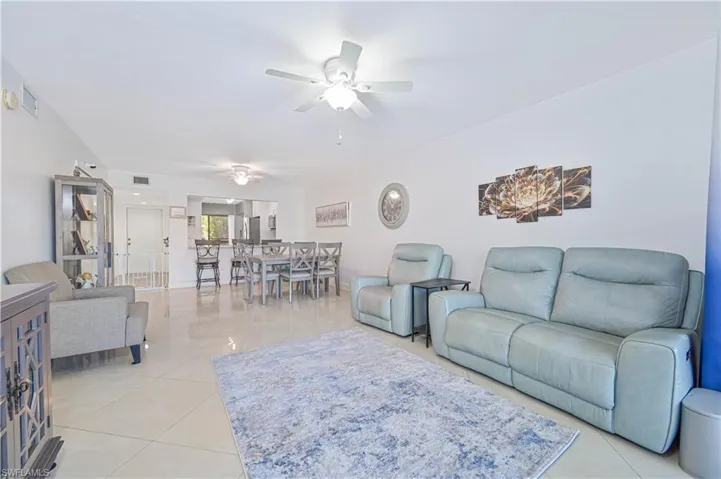Living area with ceiling fan and light tile patterned floors