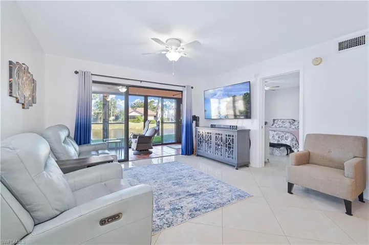 Living area with ceiling fan, french doors, and light tile patterned flooring