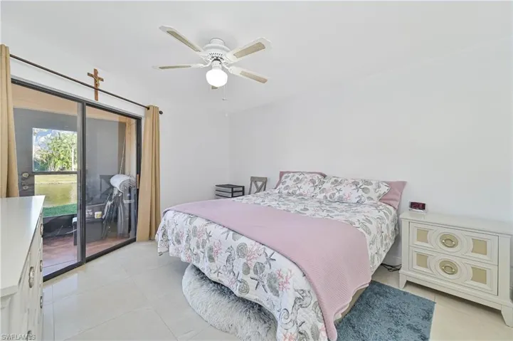 Bedroom with access to exterior, light tile patterned floors, and a ceiling fan