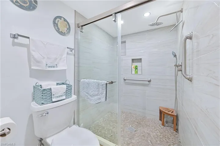 Bathroom with a stall shower and recessed lighting