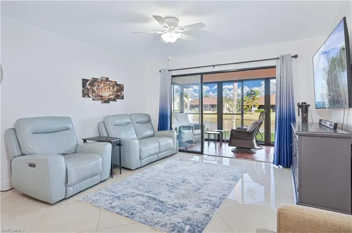Living area featuring ceiling fan and light tile patterned flooring
