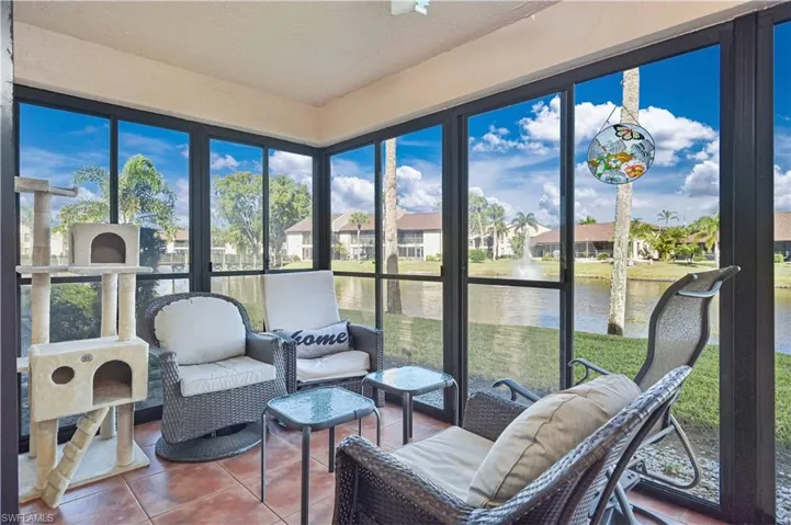 Sunroom / solarium with tile patterned floors, a water view, and a residential view