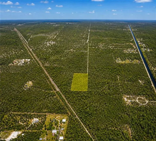 Expansive land parcel featuring dense natural vegetation and proximity to a road