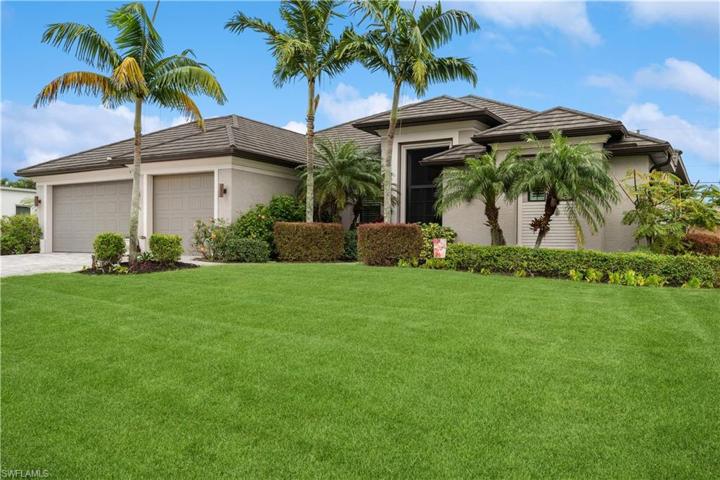 Beautifully manicured lawn and tropical plantings surround this lovely home!