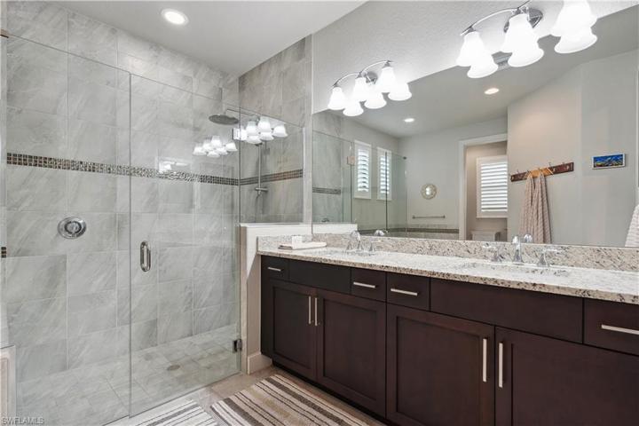 Double sink vanity and large shower with seamless glass doors