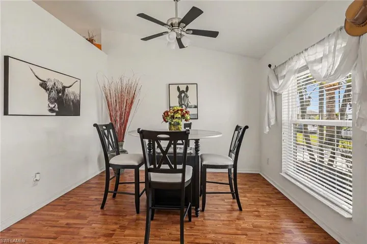 Dining space featuring wood finished floors, lofted ceiling, and ceiling fan