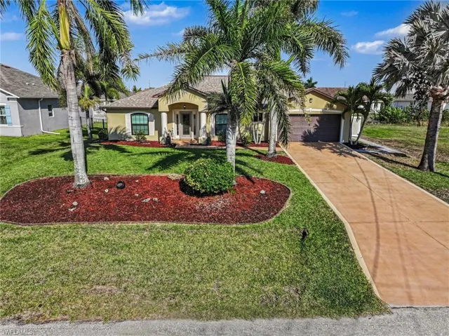 View of front of house with stucco siding, concrete driveway, an attached garage, and a front yard