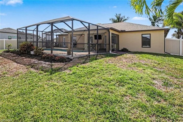 Rear view of property featuring a sunroom, a fenced backyard, glass enclosure, and stucco siding