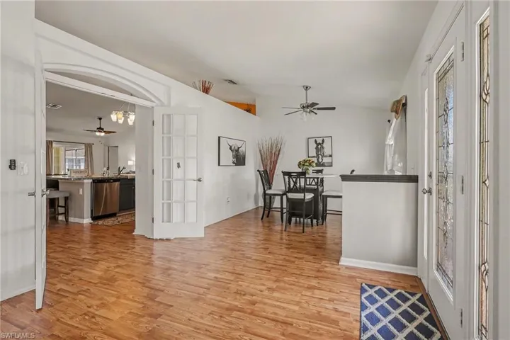 Entryway featuring ceiling fan, light wood-style floors, and vaulted ceiling