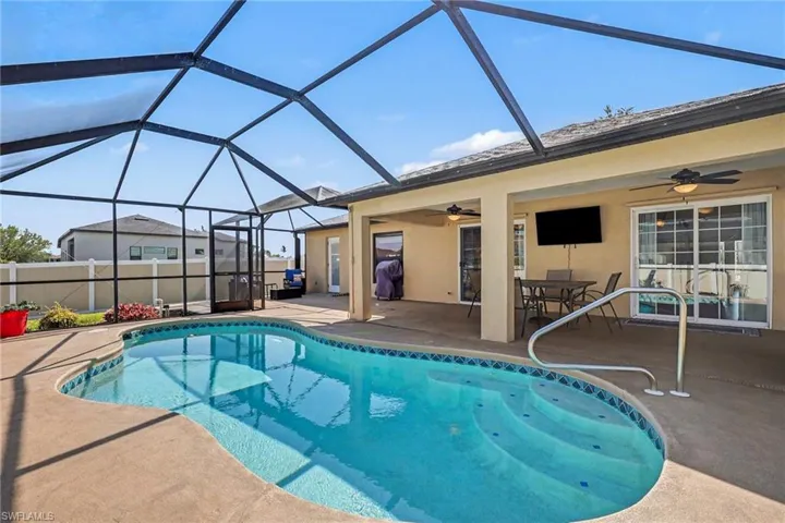 View of pool featuring an outdoor dining space, patio surround, and a lanai