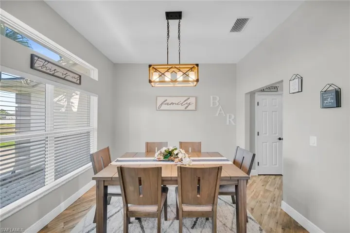 Dining space with light wood-style flooring, baseboards, and a chandelier