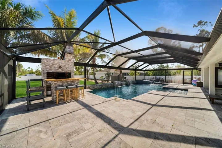 View of pool with a patio and glass enclosure