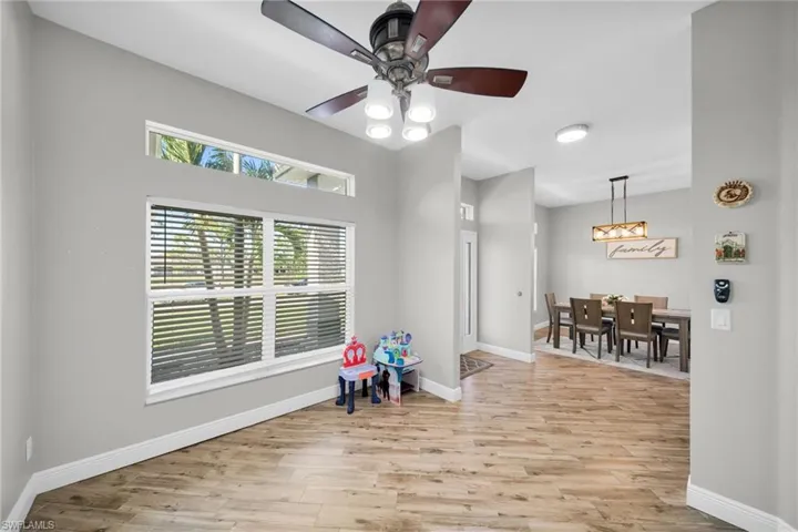 Sitting room featuring baseboards, light wood-style flooring, and a ceiling fan