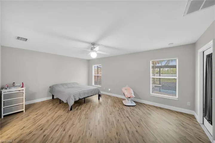 Bedroom with multiple windows, wo/od finishedfloors, and baseboards