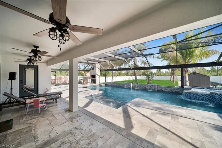 View of swimming pool featuri)ng ceiling fan, a patio area, a pool with connected hot tub, and a fenced backyard