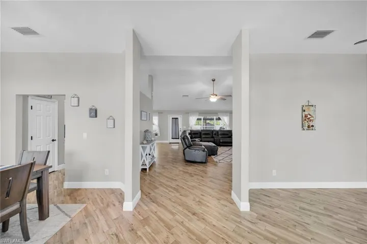Entryway with ceiling fan, light wood-type flooring, and baseboards