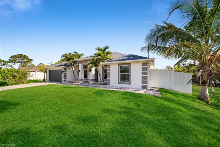 View of front of home featuring an attached garage, driveway, and stucco siding