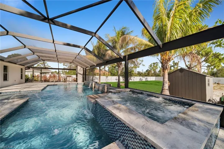 View of pool featuring a patio, a pool with connected hot tub, and glass enclosure