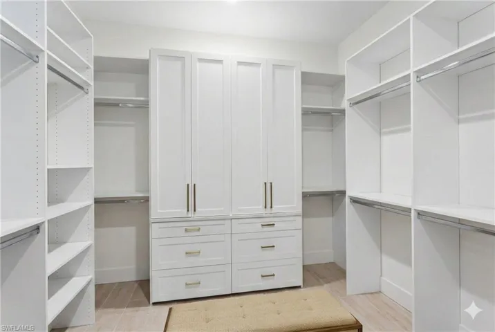 Walk in closet with light wood-style floors