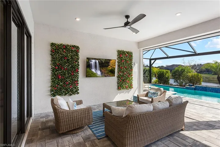 View of patio with an outdoor pool, a sunroom, glass enclosure, a ceiling fan, and outdoor seating