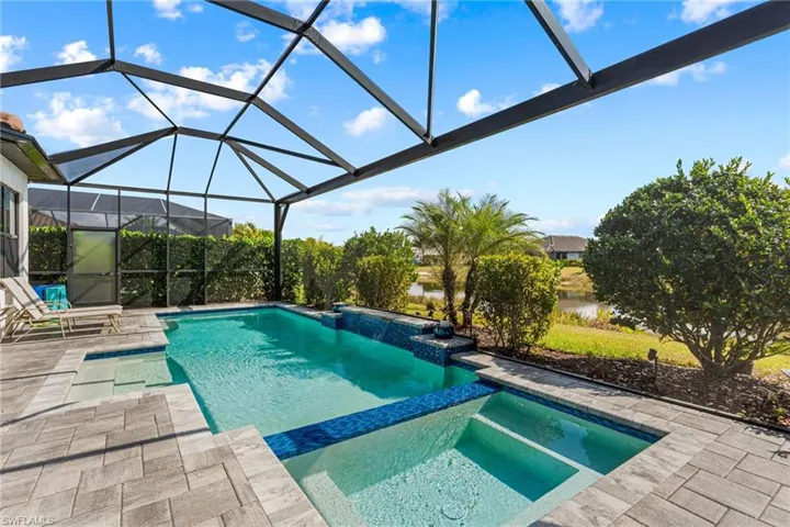 Integrated pool / spa featuring a patio, a lanai, a water view, and a sunroom