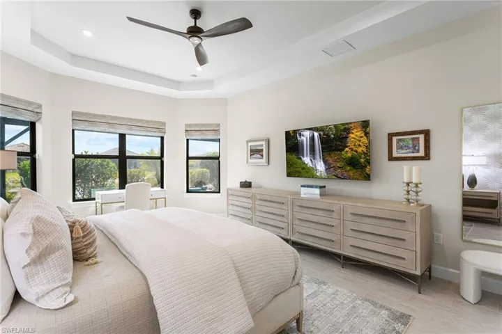 Bedroom featuring a tray ceiling, ceiling fan, light wood-type flooring, and recessed lighting
