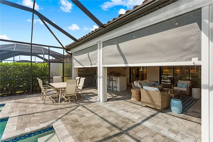 View of patio / terrace with a lanai, an outdoor pool, a sunroom, and an outdoor bar and dining area