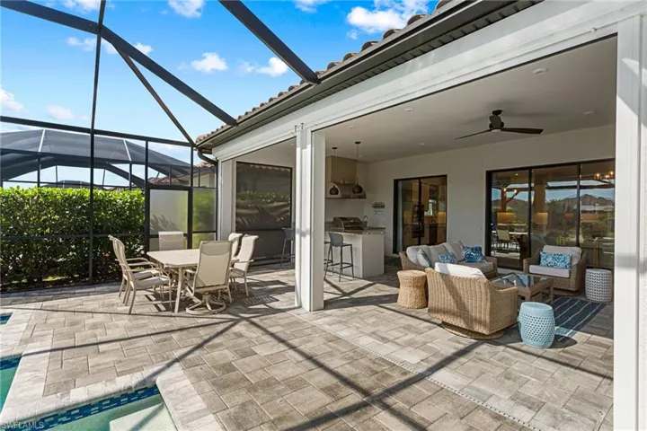 View of patio / terrace featuring a lanai, an outdoor living / dining area, ceiling fan, a sunroom, and area for grilling