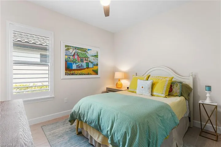 Bedroom with ceiling fan and light wood-style flooring