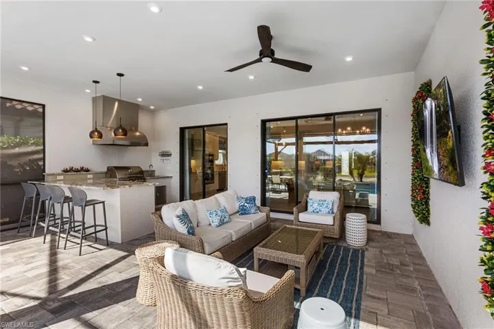 View of patio / terrace featuring area for grilling, ceiling fan, and an outdoor lounge area with bar